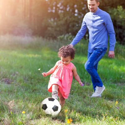 petite fille et papa jouent au foot